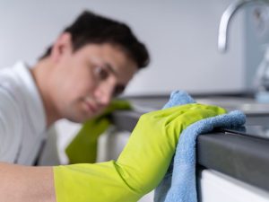 un homme nettoyant un plan de travail de cuisine